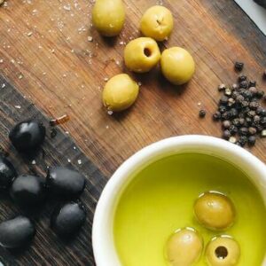 Aceite de oliva verde acompañado de pan y aceitunas